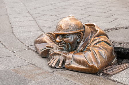 BRATISLAVA, SLOVAKIA - DECEMBER 16, 2016:  Bronze sculpture Cumil (The Watcher) or Man at work in old townのeditorial素材