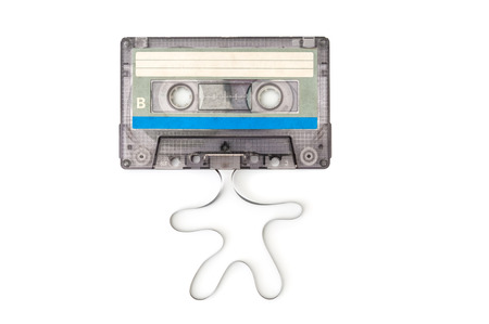 Audio cassette with unwound tape in the shape of a man on white backgroundの写真素材