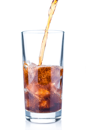Cola pouring into glass filled ice cubes on white backgroundの写真素材