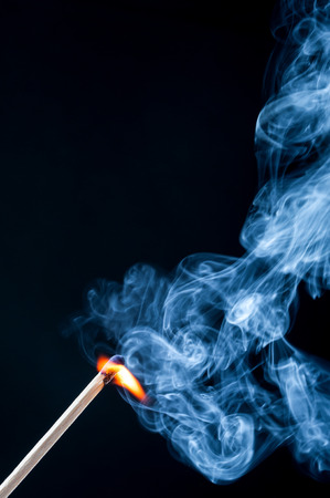 Ignition match with smoke on black backgroundの写真素材