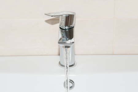 Faucet with flowing water close upの写真素材