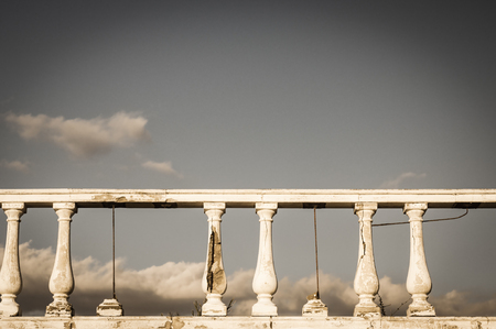 Damaged balustrade on clouds sky backgroundの写真素材