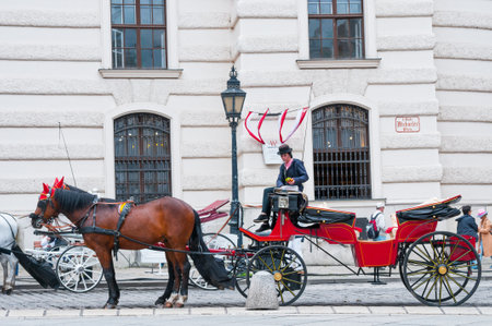 VIENNA, AUSTRIA - JUNE 04, 2017: Traditional old-fashioned fiacres at Michaelerplatz near Hofburg のeditorial素材