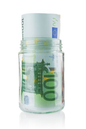 Euro banknotes in glass jar isolated on white backgroundの写真素材