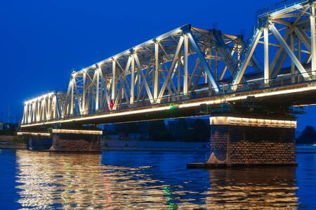 Railway bridge across the river at nightの写真素材