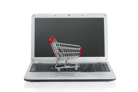 Shopping cart over laptop isolated on white backgroundの写真素材