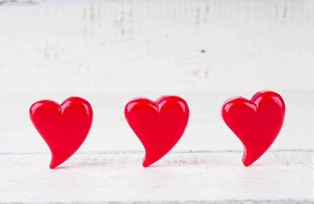Three red hearts close up on wooden background. Valentines day cardの写真素材