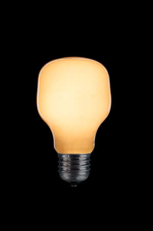 Glowing light bulb close up on black background