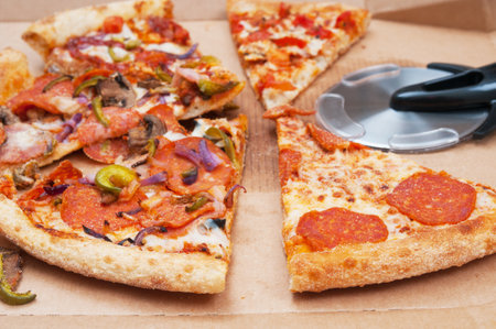 Used opened pizza and cutting knife in cardboard pack close up
