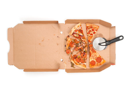 Used opened pizza and cutting knife in cardboard pack on white backgroundの写真素材
