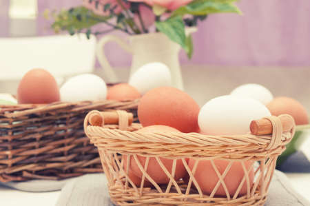 Easter eggs in the wickers basket at home interiorの写真素材