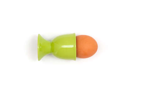 Egg in a ceramic green stand on white background