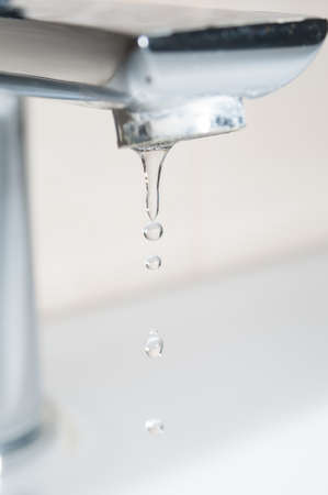 Metal tap with leaking water close upの写真素材