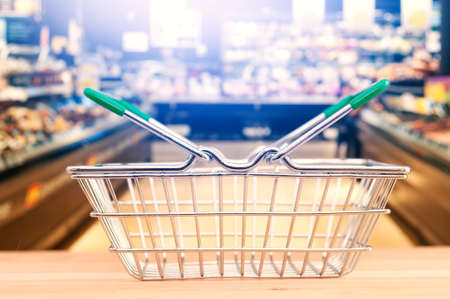 Empty shop basket on blurring supermarket aisle backgroundの写真素材