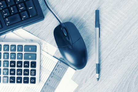 Business workspace desk with pc keyboard, calculator and accounting paper. Toned imageの写真素材