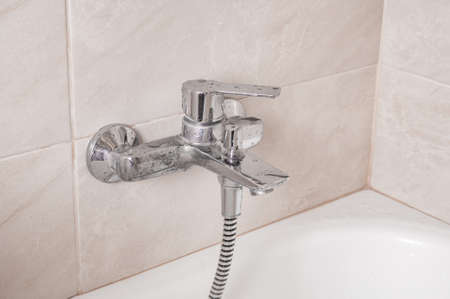 Chrome tap in bathroom close up