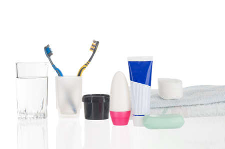 Toothbrushes with water glass, paste, soap and towel isolated on white background