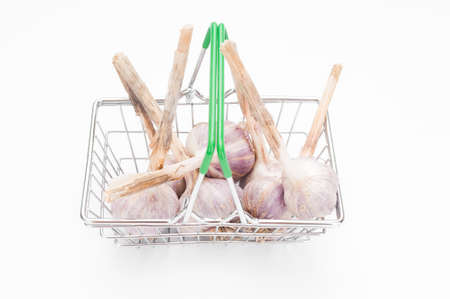 Shopping basket with garlic bulbs on white background