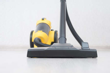 Vacuum cleaner with sweeping brush on wooden floor. front focusの写真素材