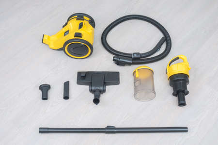 Parts of vacuum cleaner on a wooden floorの写真素材