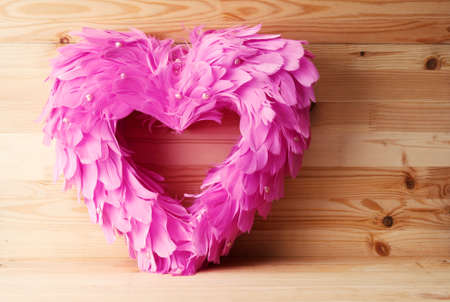 Feathered heart on wooden background. valentines day cardの写真素材
