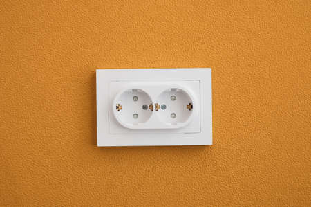 Electrical outlet close up in the yellow wall backgroundの写真素材
