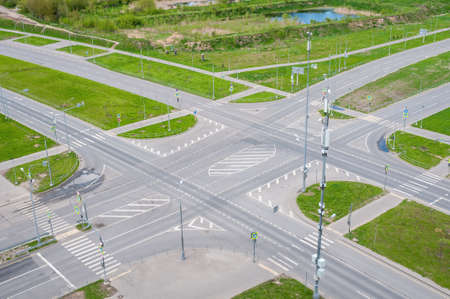 View above of empty street intersection, with crosswalk markings and traffic signal lightsの写真素材
