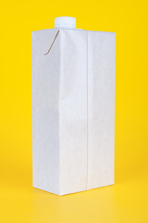 Milk carton box close up on a yellow backgroundの写真素材