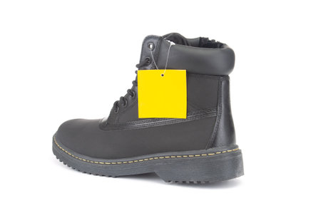 Black winter boot close up with tag isolated on white backgroundの写真素材