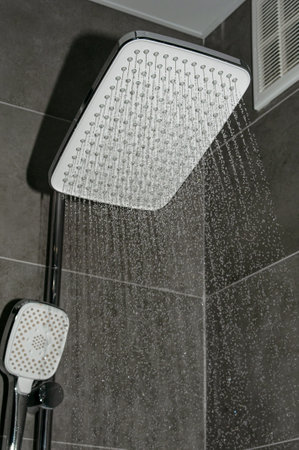 Water running from modern chrome shower head in the bathroomの写真素材