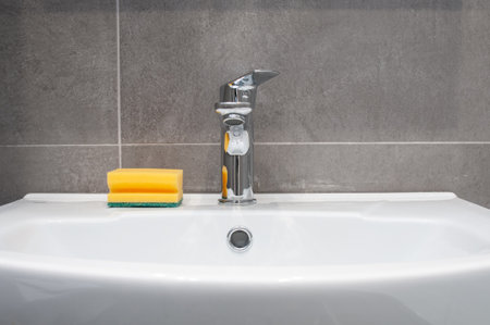New ceramic sink and chrome faucet in a bathroomの写真素材