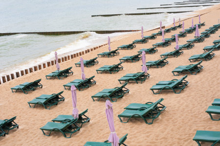 Row of empty lounger decks on a sand beachの写真素材