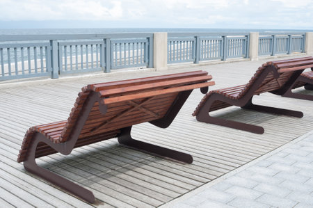 Empty wooden benches along sea coastlineの写真素材