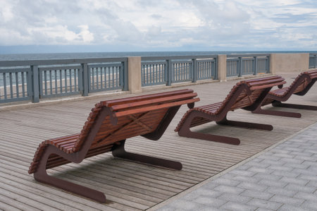 Empty wooden benches along sea coastlineの写真素材