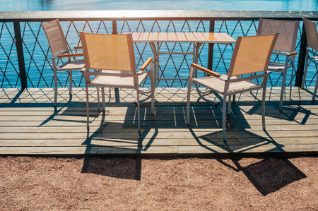 Table and chairs in coastline cafe near seaの写真素材