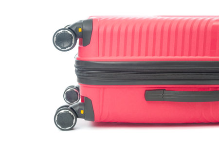 Red travel bag with rollers close up on white backgroundの写真素材