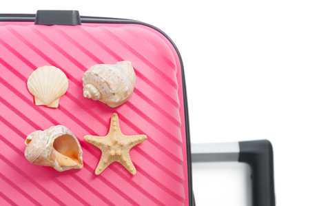 Red travel bag and seashells close up on white background. travel conceptの写真素材