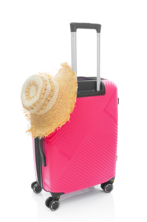 Red plastic travel bag with straw hat on white backgroundの写真素材