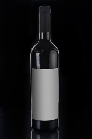 Red wine bottle close up on a black backgroundの写真素材