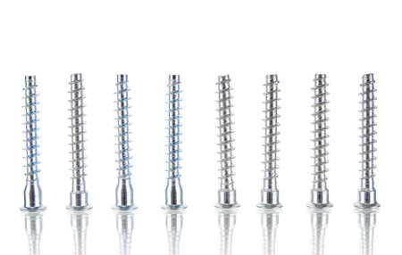 Row of metal screws isolated on white backgroundの写真素材