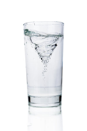 Water tornado in water glass close up isolated on white backgroundの写真素材