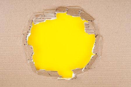 Torn edge cardboard corrugated on a yellow backgroundの写真素材