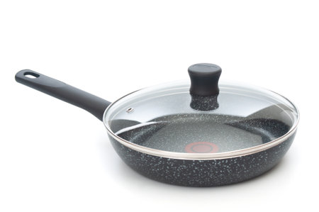 Frying pan with glass lid close up on a white backgroundの写真素材