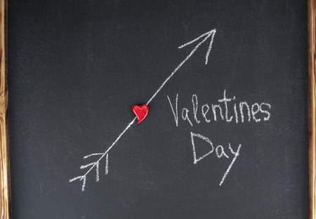 Inscription  Valentines Day  with red heart on a blackboard. Valentines day card
