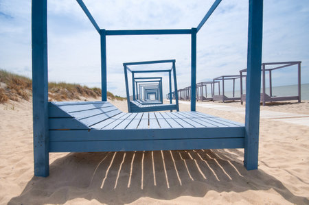 Wooden sun loungers on a sandy beach
