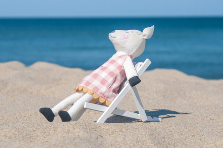 Toy mouse sitting on a beach chair at seashoreの写真素材