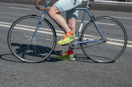 Hipster man and his fixed gear bicycle on asphalt roadway