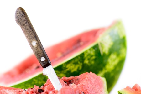 Some of the watermelon was already eaten. A wooden-handled knife with a delicious slice. In the...