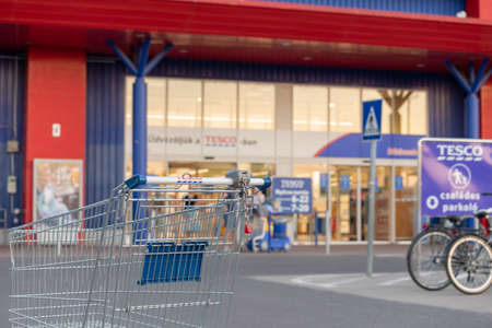 BEKESCSABA, HUNGARY, 08 JUN 2021 - An empty tesco shopping cart before the main entrance. The supermarket is also visible.のeditorial素材
