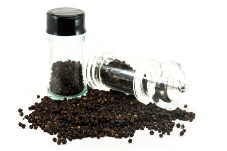 Glass bottle and Pepper Grinder of black peppercorn with Dried whole peppercorn on white background